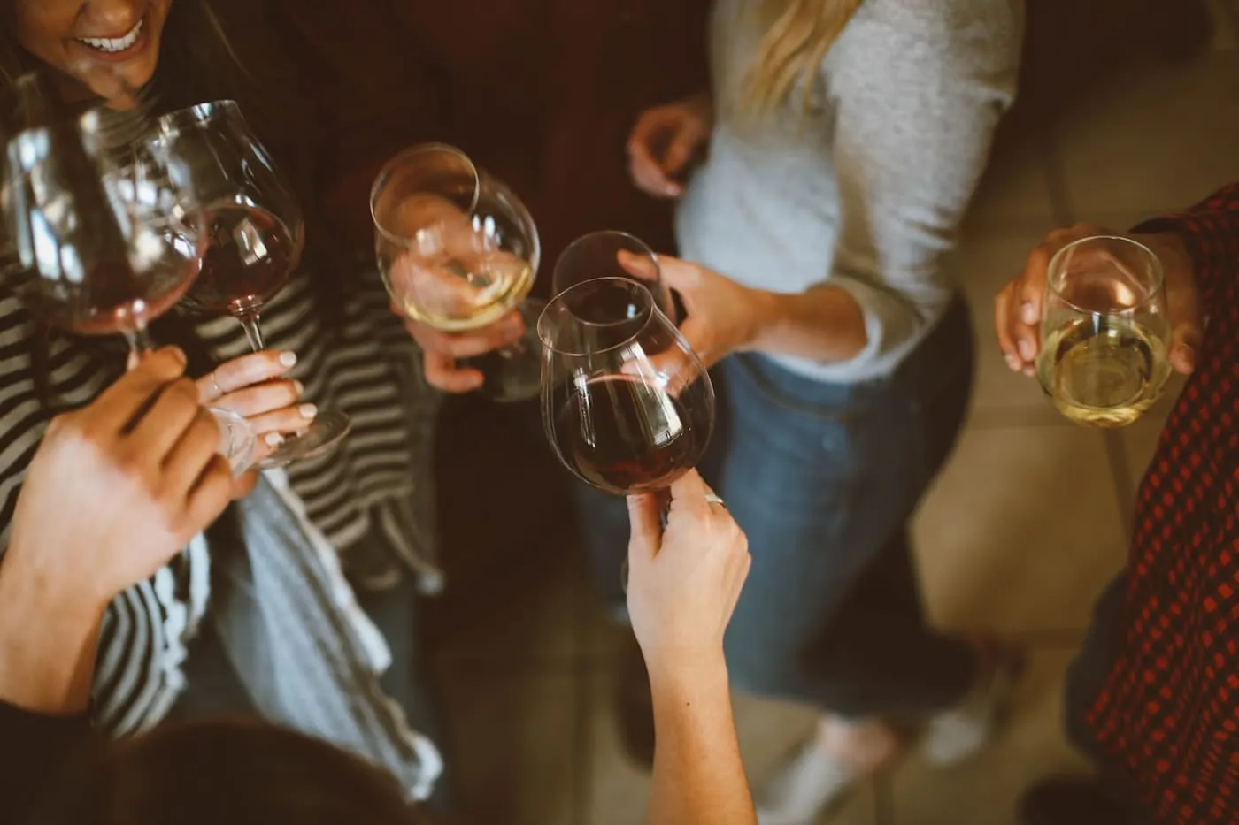 Guests raising wine glasses together during an alfresco dinner — the kind of evening a well-lit, well-hosted space encourages