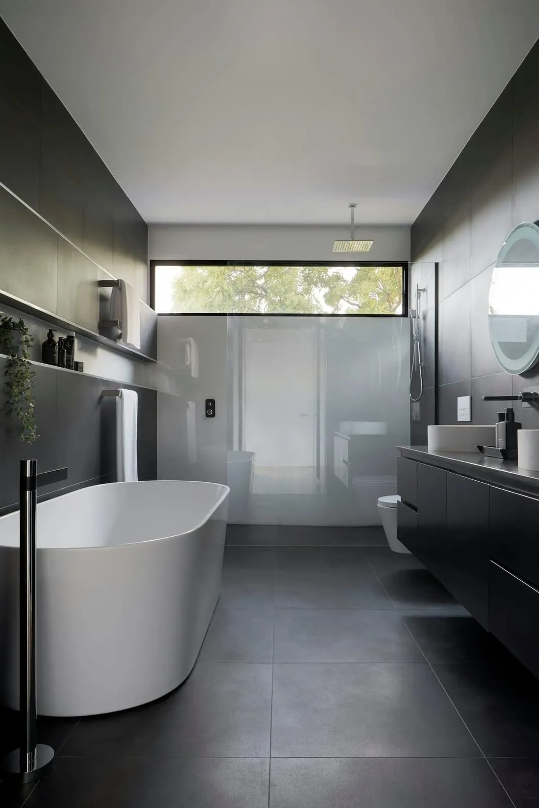 Freestanding bath in white stone composite with a coastal candle and timber bath tray